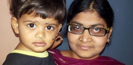 Woman carrying her son while wearing eyeglasses