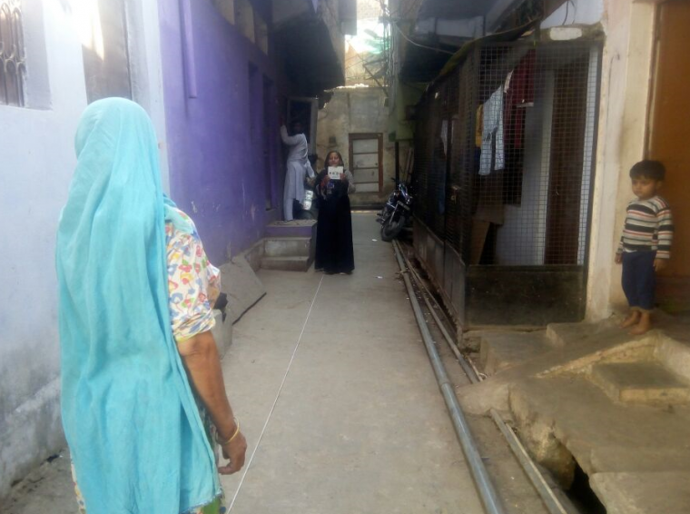 Indian community health worker tests a woman's visual acuity in her community