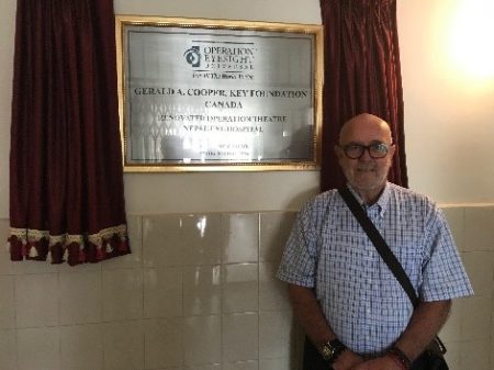 Foster pictured here beside a plaque inaugurating the newly upgraded operating theatre at the Nepal Eye Hospital, made available through gracious donor support.