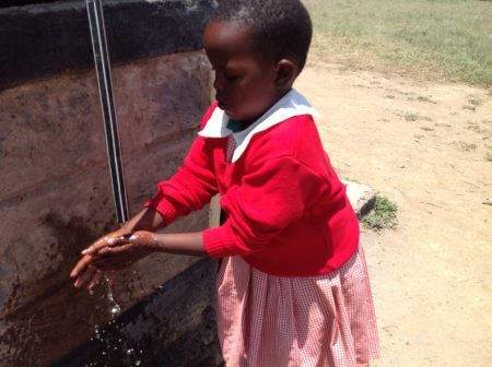 African child washing her hands to prevent the spread of trachoma.