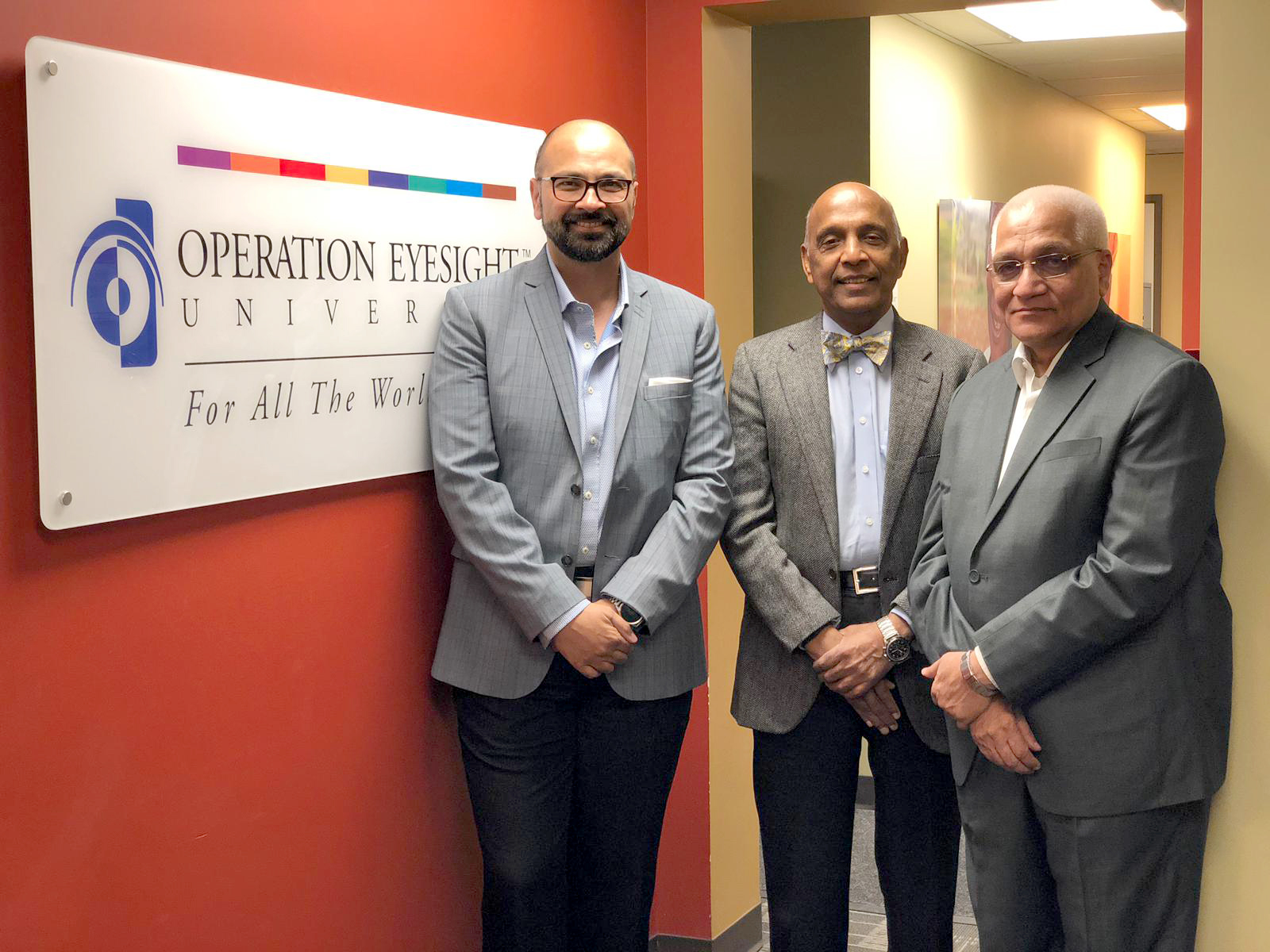 Aly Bandali, Dr. rao, and Dr. Das standing infront of Operation Eyesight Universal.