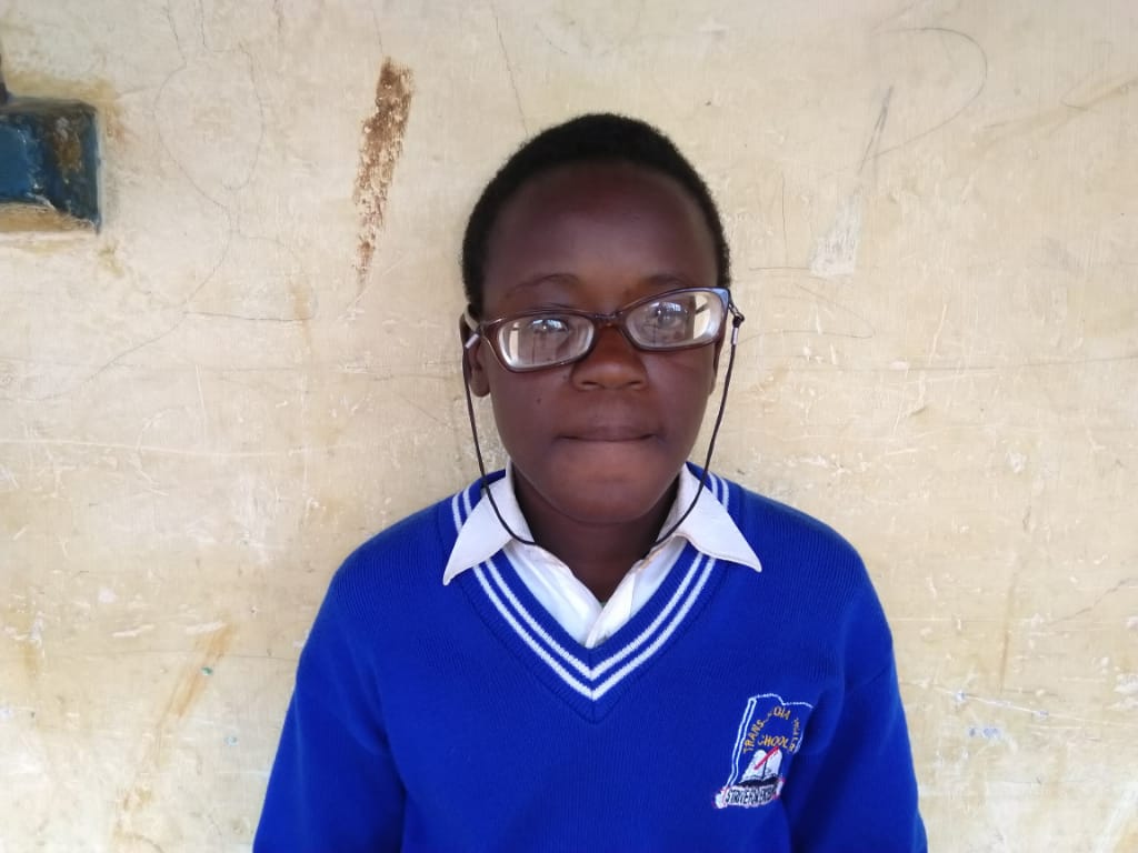 Hellen, wearing her eyeglasses, looking at the camera