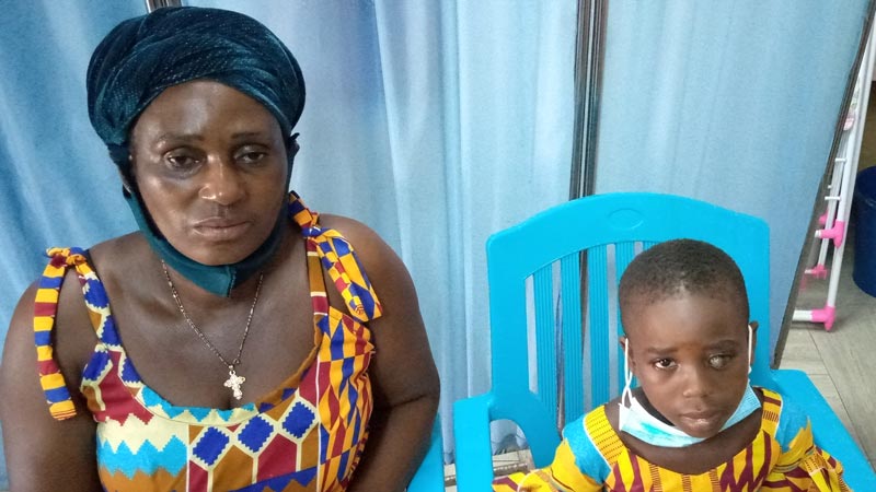 A child, with visual impairment in her left eye, sits with her mom