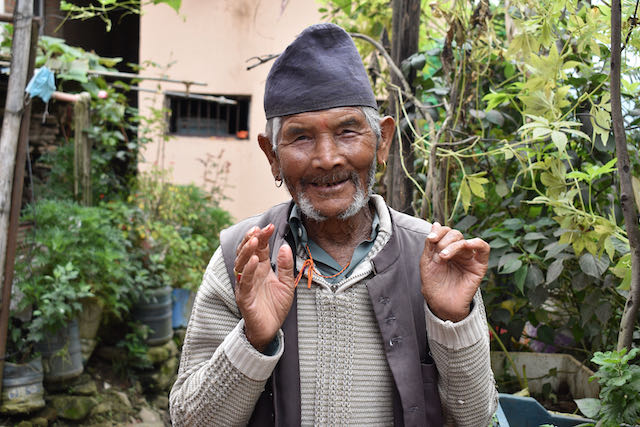 A senior man smiling at the camera