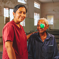 A hospital staff stands with a patient after his surgery