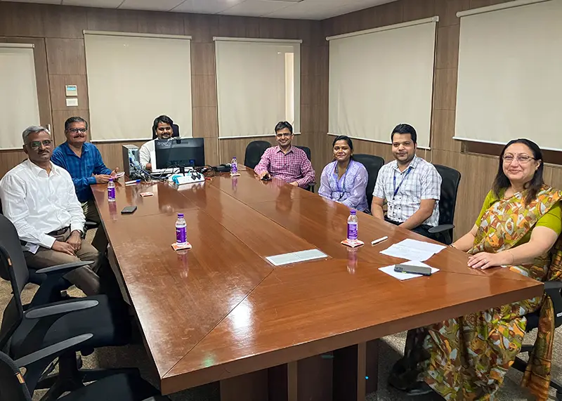 A group of professionals sits around a board room table.