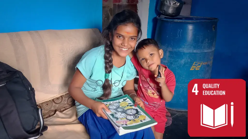 A teenage girl holding a book smiles while sitting on a couch with a younger child