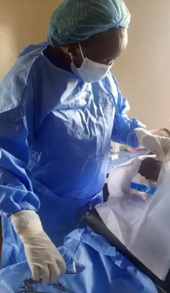 Ophthalmologist in a surgical gown and mask preparing instruments and Napolo for the upcoming eye surgery.